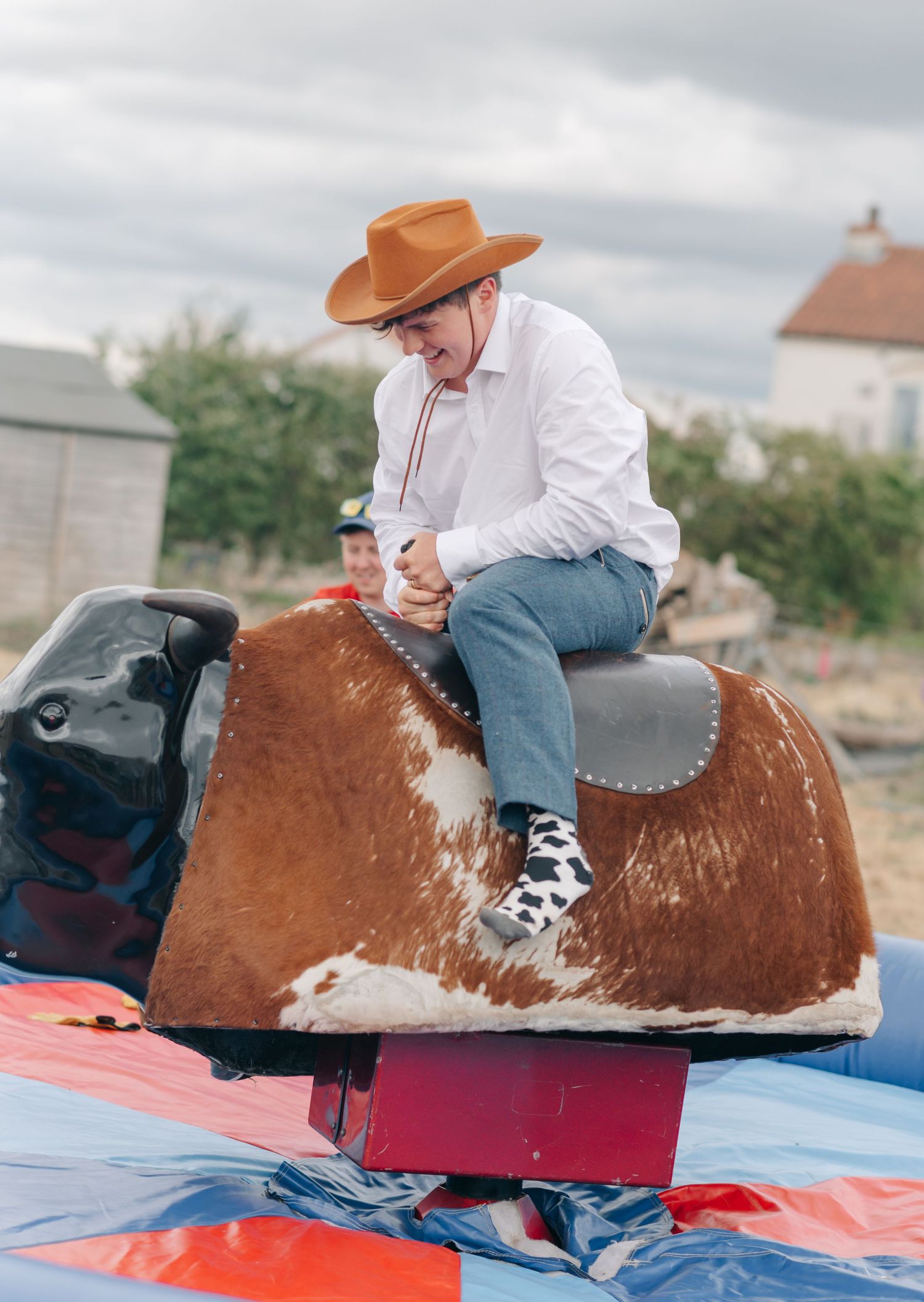 Mechanical bull riding entertainment at an outdoor wedding reception.