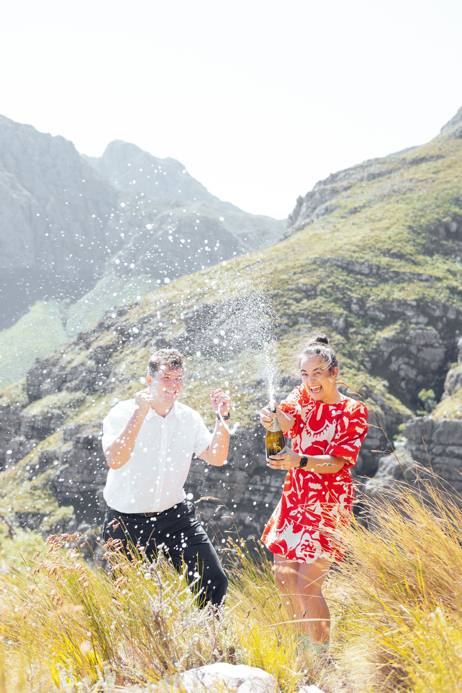 A celebratory moment with champagne spraying against a mountainous backdrop.