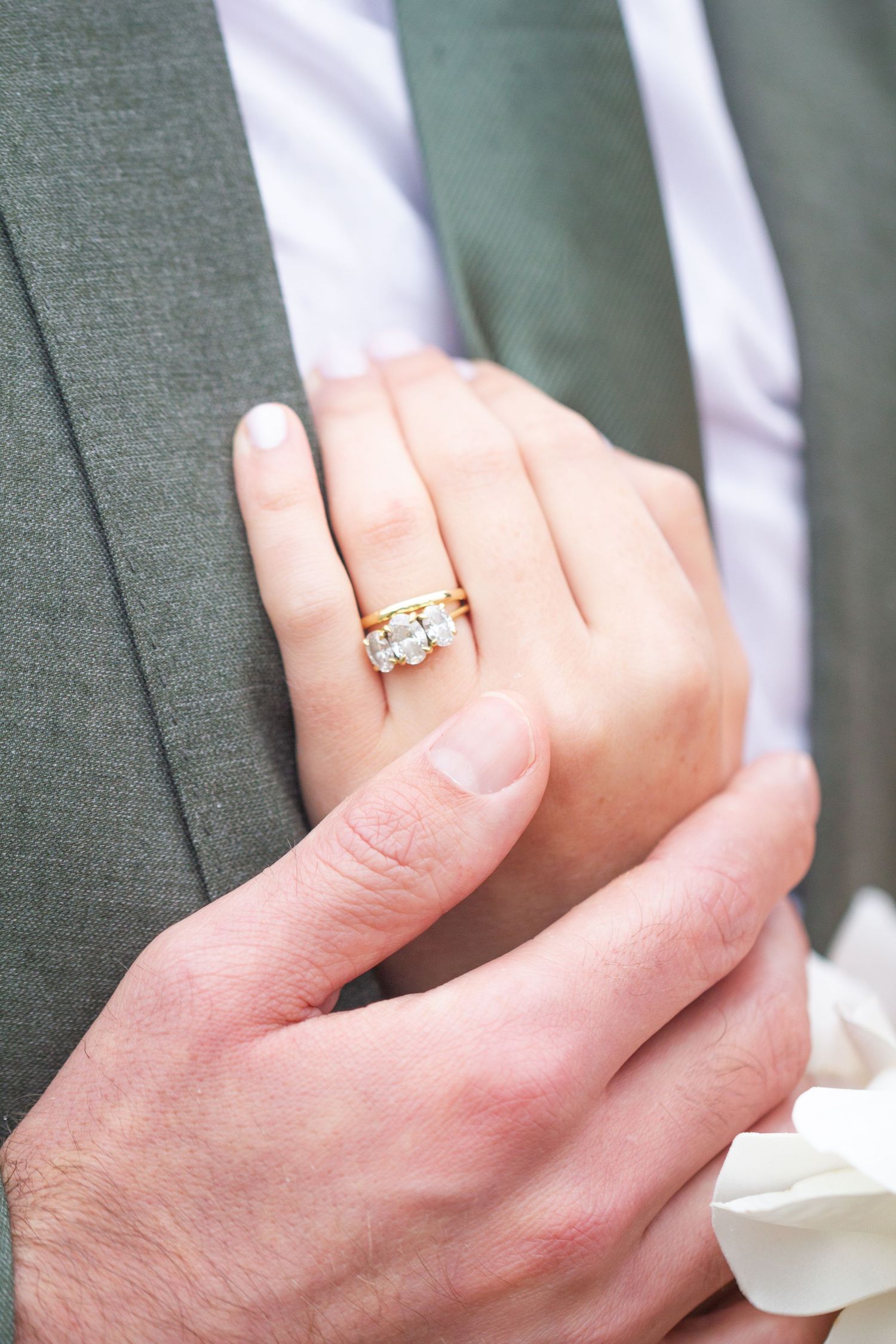 Close-up series of hands displaying a sparkling engagement ring with a white gold band and center diamond stone.