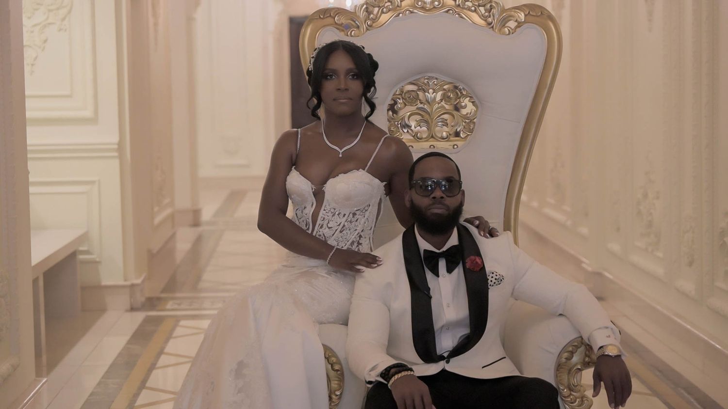 Elegant wedding portrait in an ornate room with gilded furniture.