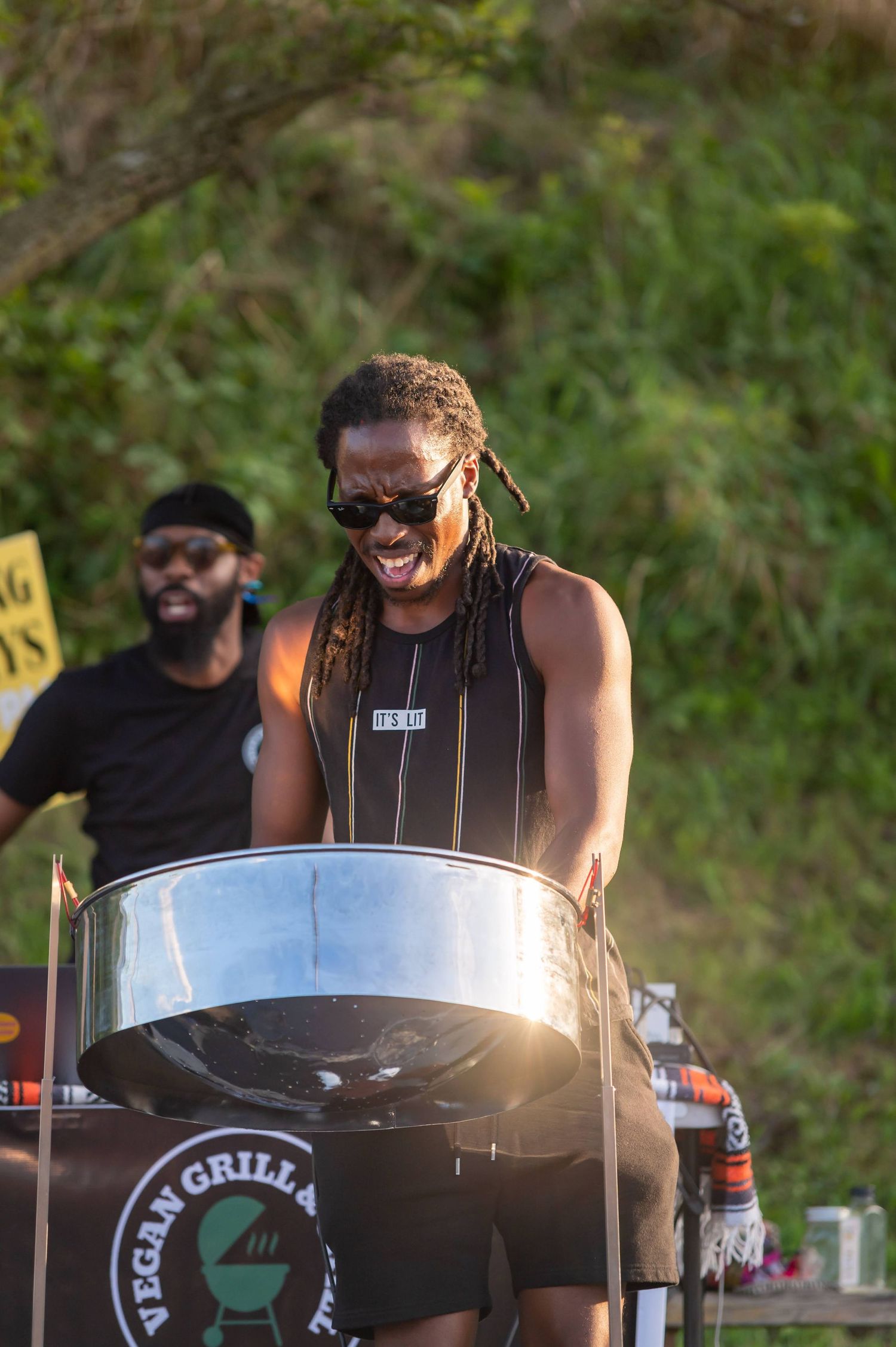 Musician performing on steel drums at an outdoor event.