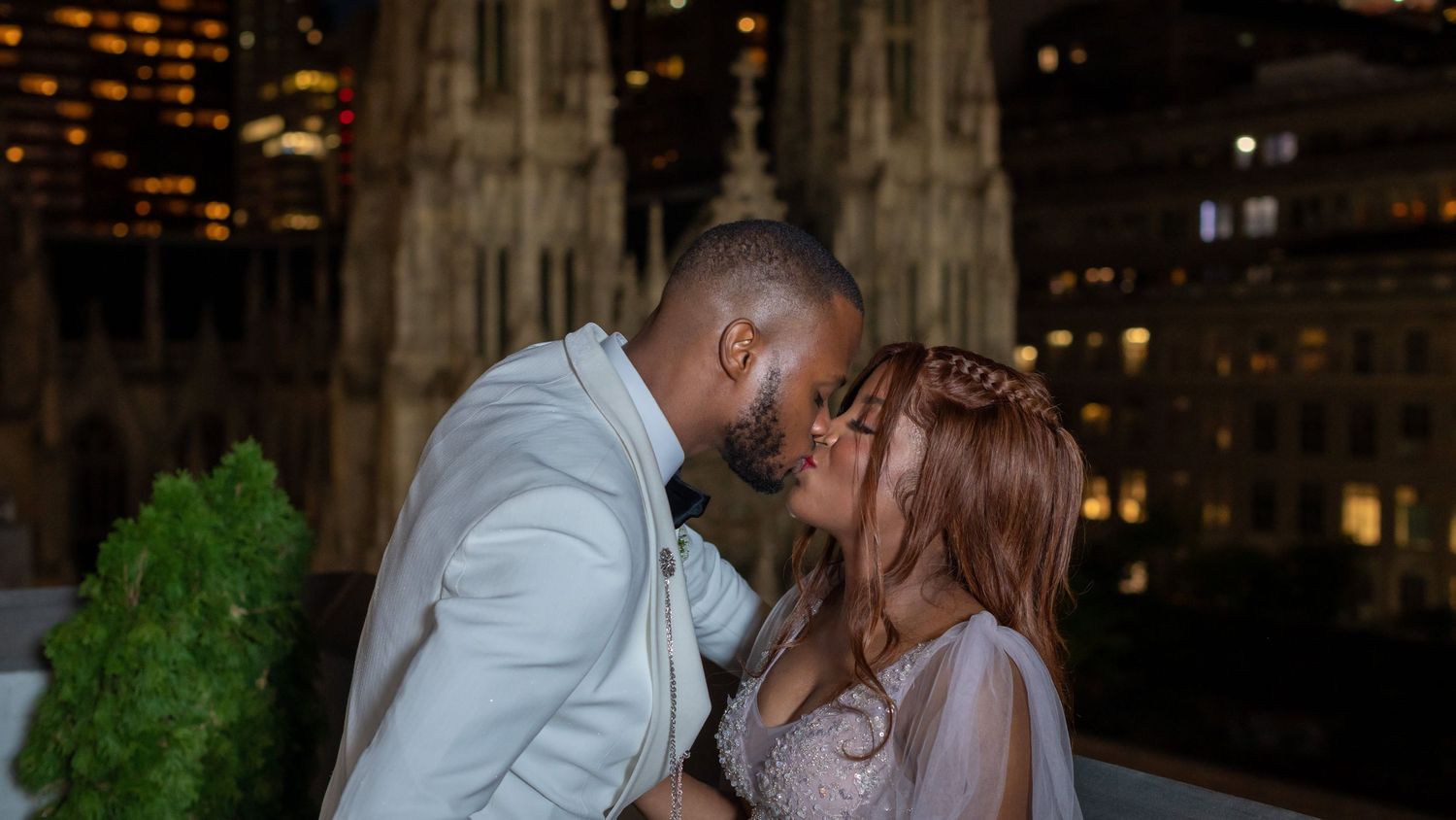 A romantic nighttime city photoshoot with a Gothic cathedral backdrop and glowing city lights.