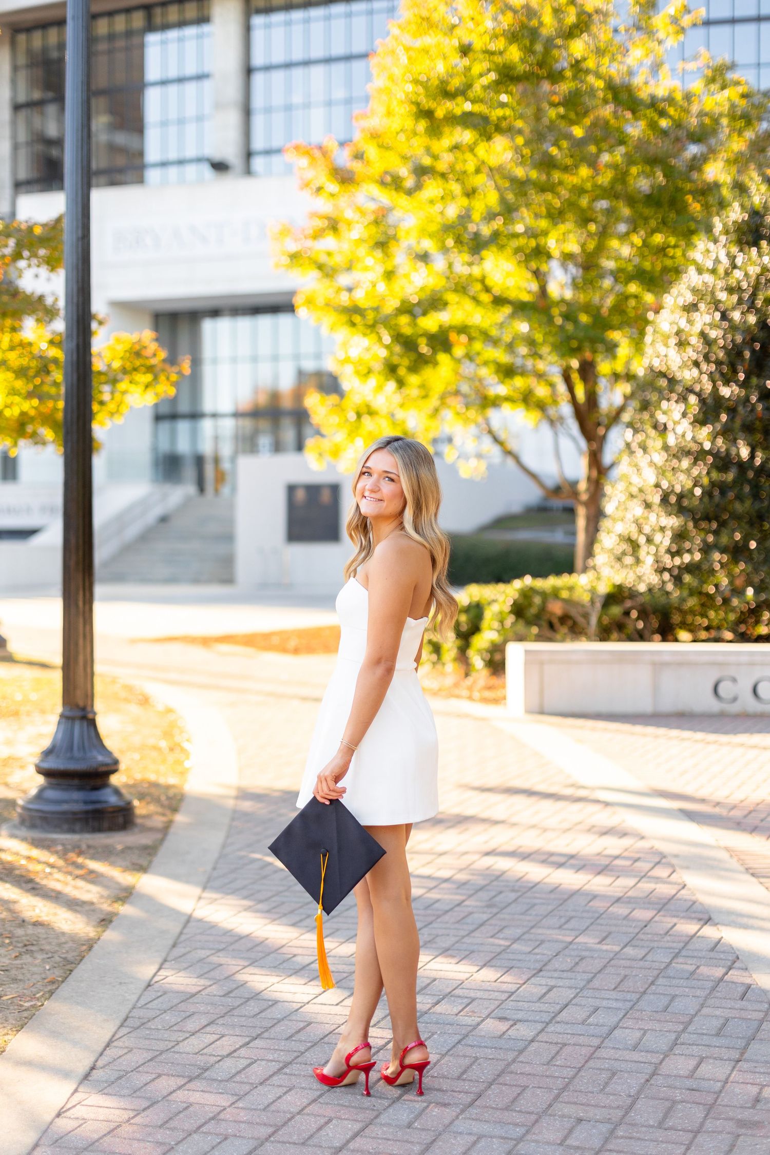 A series of outdoor graduation portraits with autumn trees and brick pavers in the background.