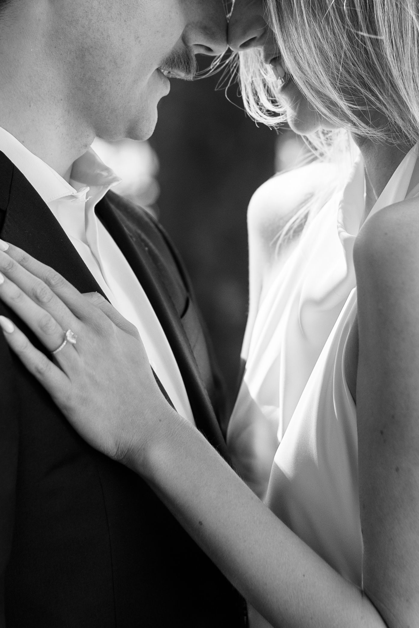Black and white romantic photo series showing an intimate moment between a couple in formal attire.