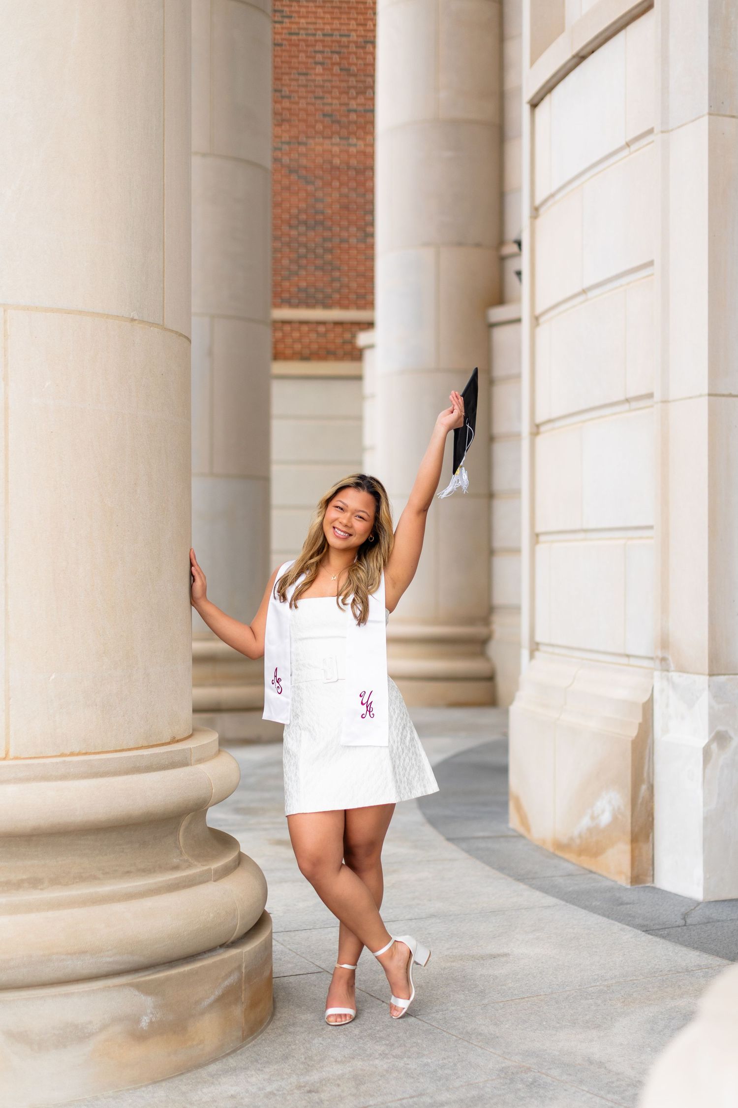 A person in a white dress poses playfully between classical stone columns in a series of four connected photos.