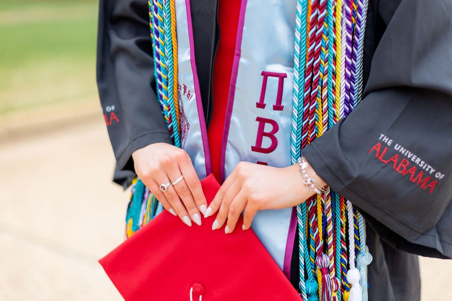 Graduation stole with colorful cords and Greek letters showing Pi Beta details.