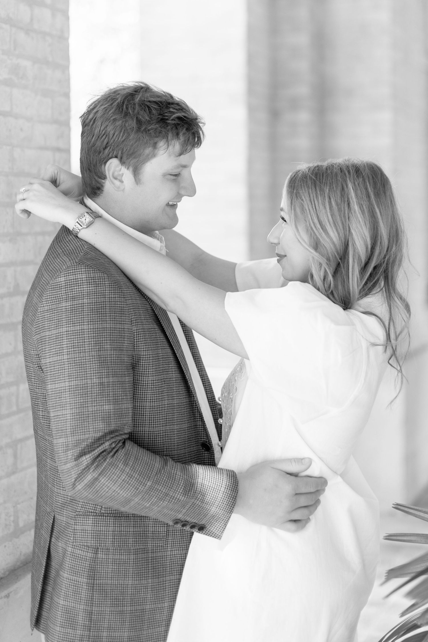A romantic black and white photo series showing a couple in wedding attire embracing and sharing intimate moments.