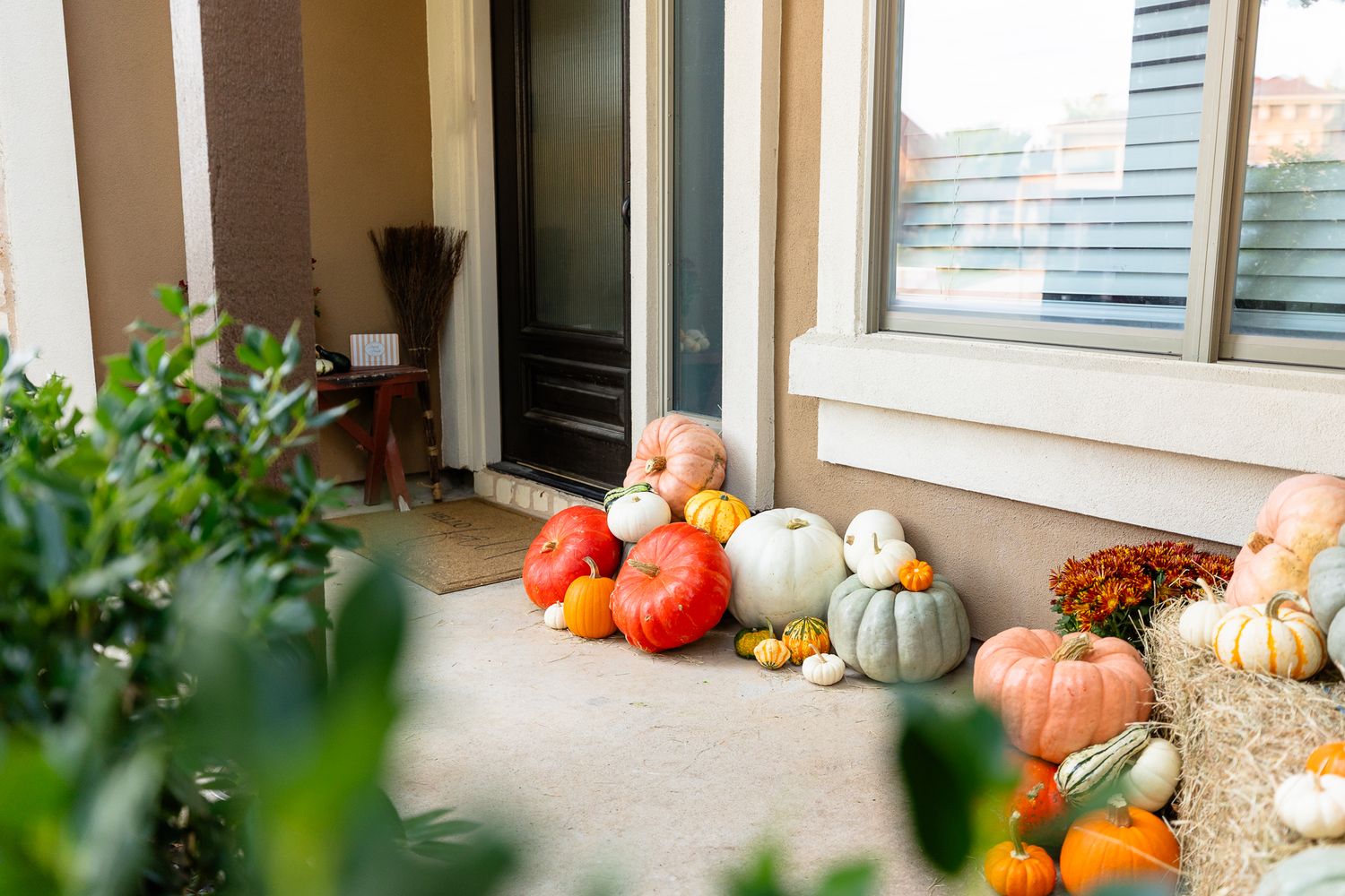 Fall pumpkins, gourds, cornucopias and autumn decorations arranged on an outdoor window sill for seasonal display.