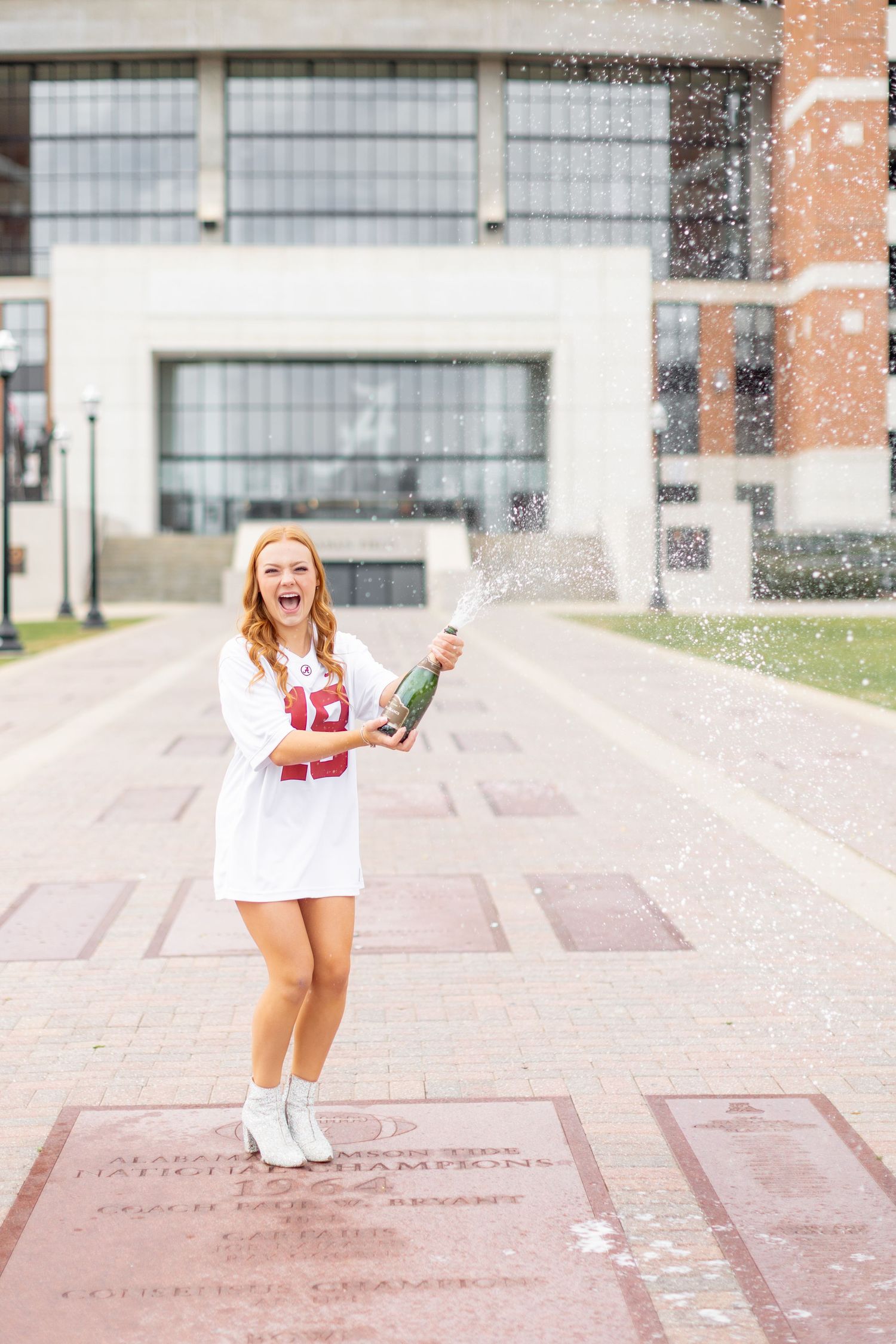 A series of celebratory jumping poses captured on a paved courtyard with brick buildings in the background.