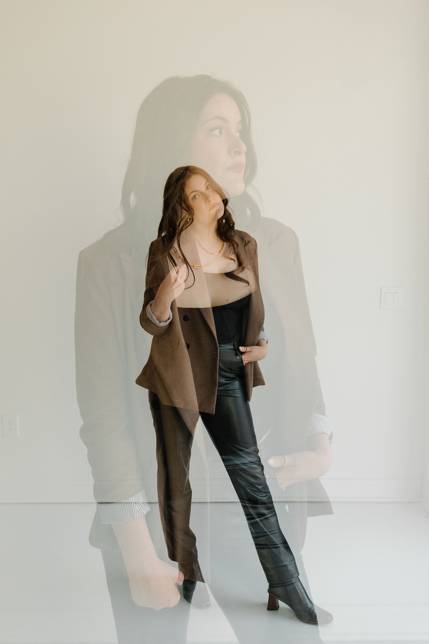 Modern photo with artistic shadow effect showing brown blazer and leather pants ensemble. Photographer Hannah Rogg Taylor.