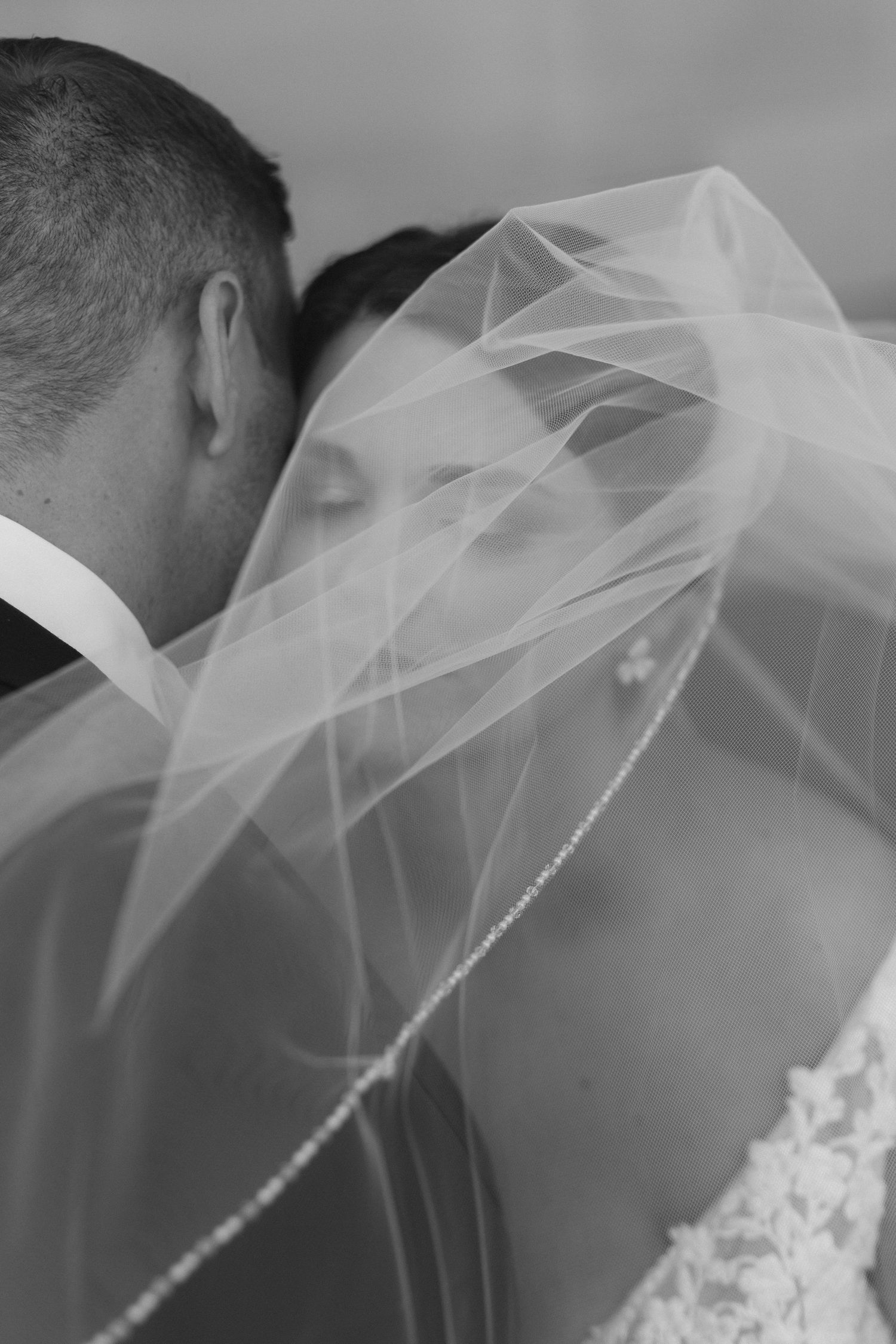 Close up black and white shot of flowing bridal veil at outdoor wedding ceremony. By Hannah Taylor for epagaFOTO.