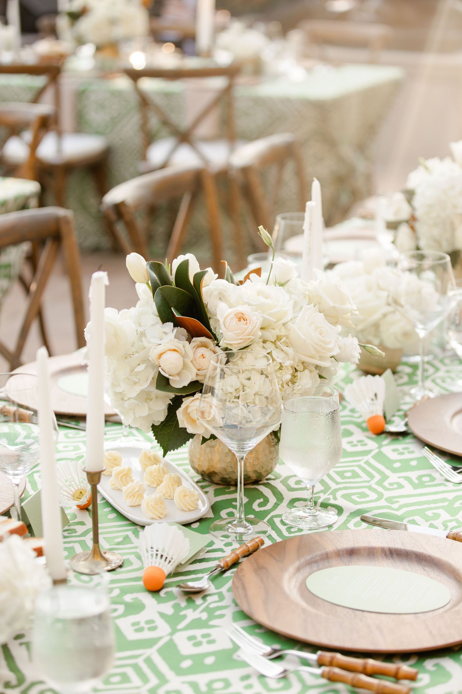 Elegant table setting with white floral centerpieces, soft green patterned tablecloth for a wedding reception at Nelson Atkins Art Musuem.