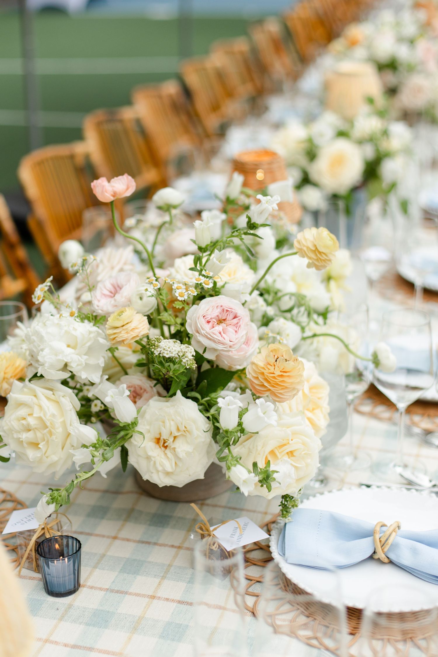 Elegant wedding table setting with lush peach and cream floral centerpiece on checkered tablecloth in Kansas City.