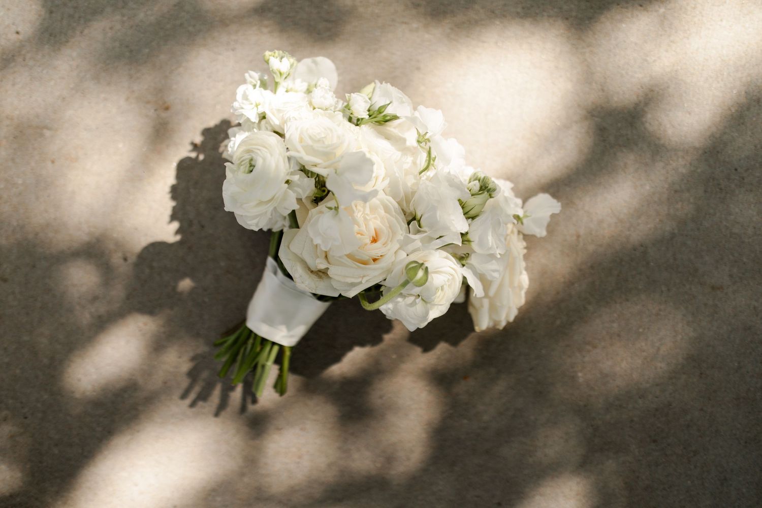 Classic white wedding bouquet photographed in dappled shadows with dreamy effect. KC Wedding Photographer.