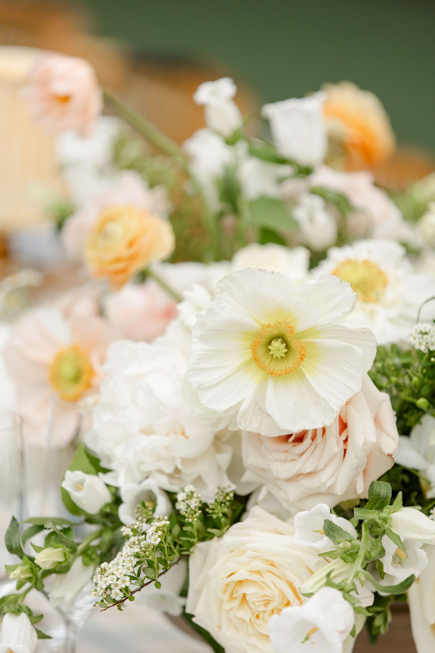 Romantic floral arrangement with white poppies, roses and delicate greenery.