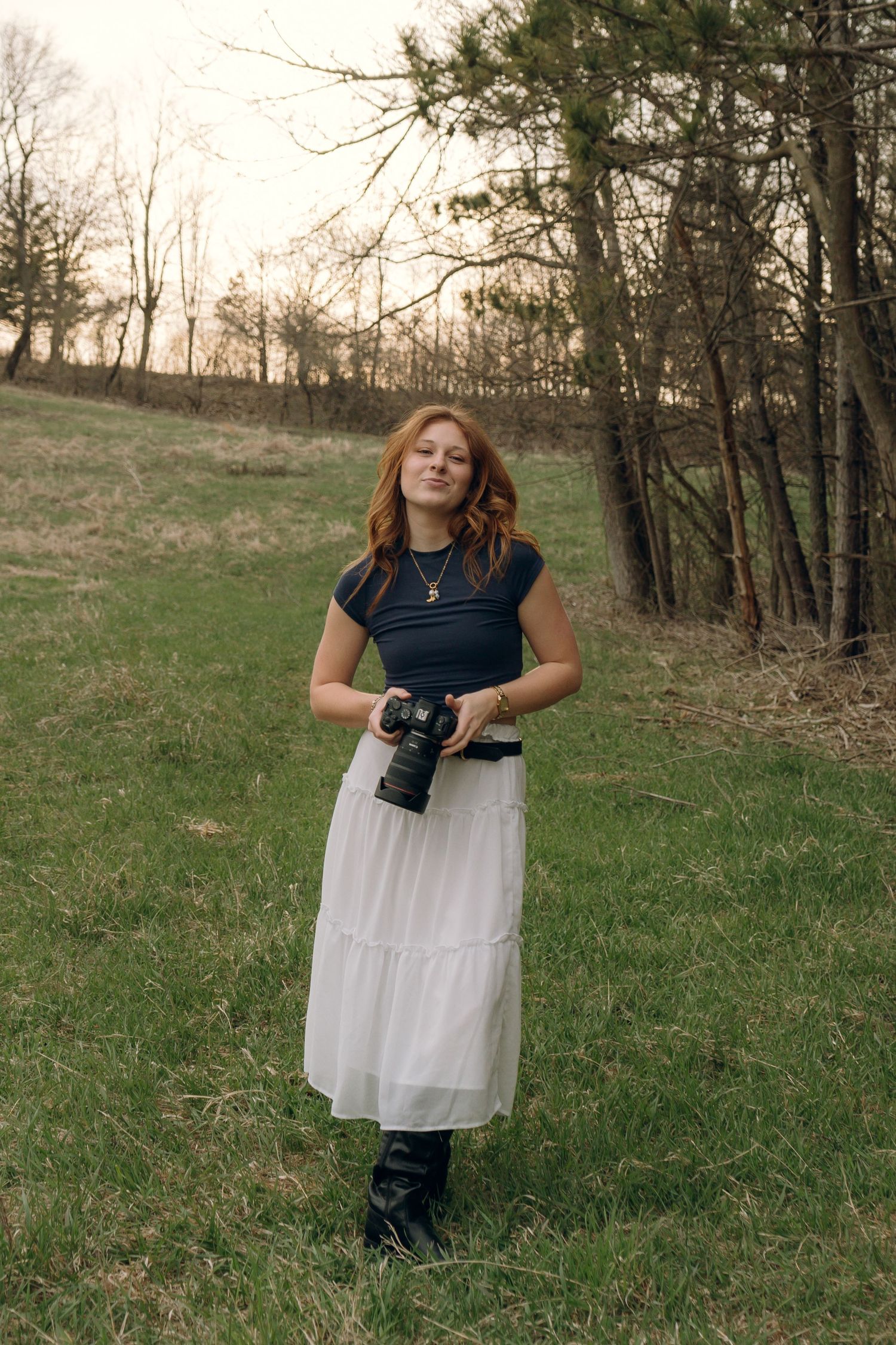 Photographer holding a camera and smirking, capturing playful confidence and creative personality