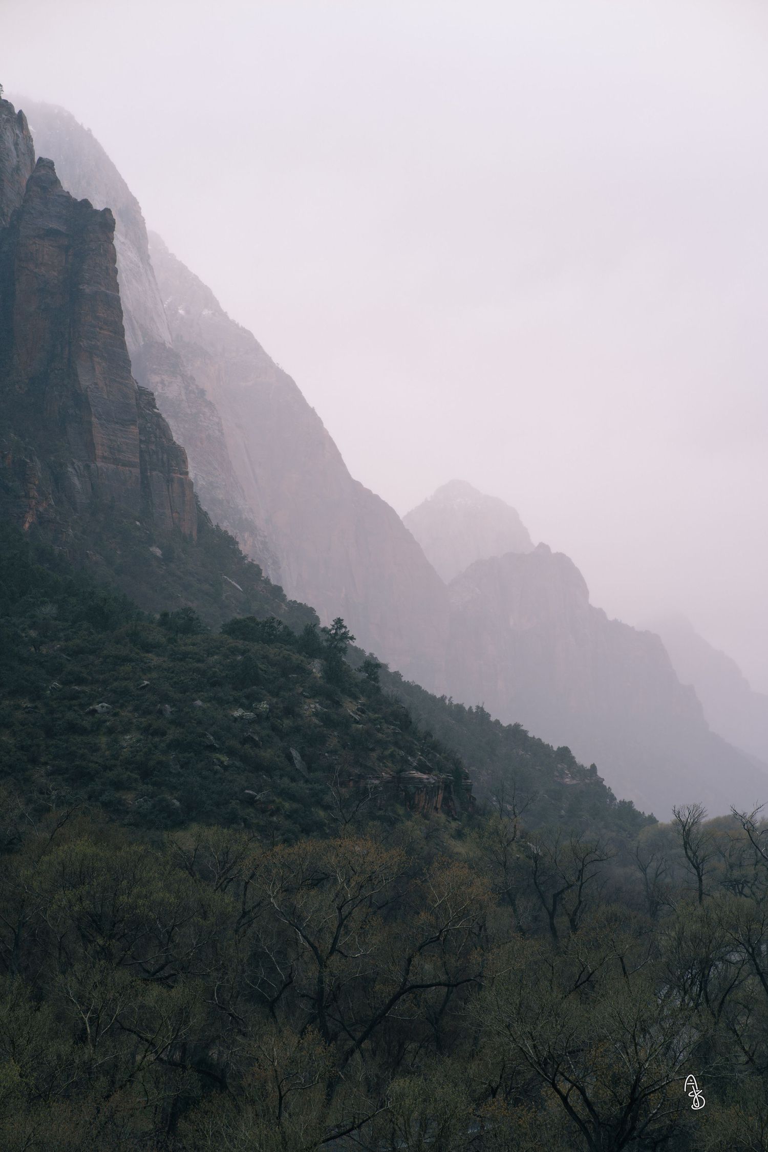 Moody landscape photo with Mountain with foggy peaks in distance.