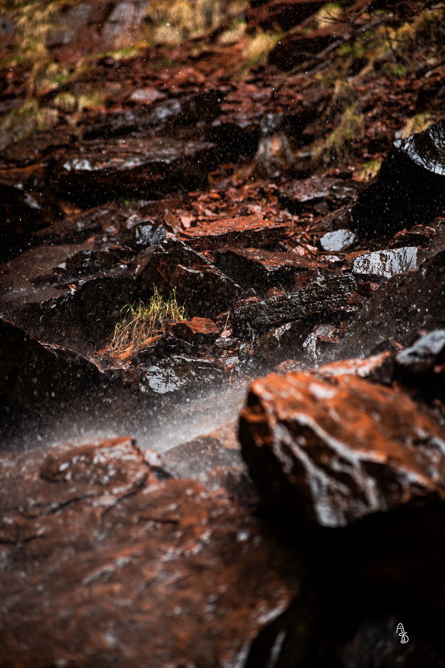 Water ripples through wet rocks.