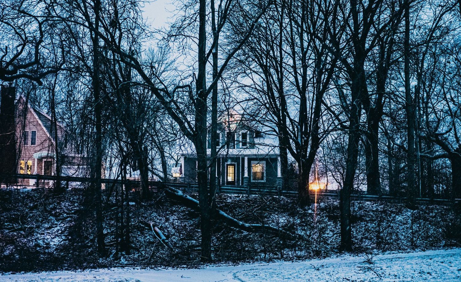 Dimly lit winter cabin and woods landscape