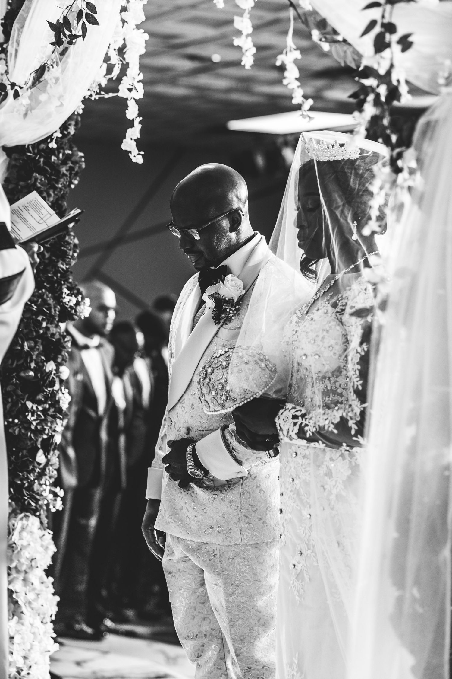 Bride and groom join hands standing and wedding altar.
