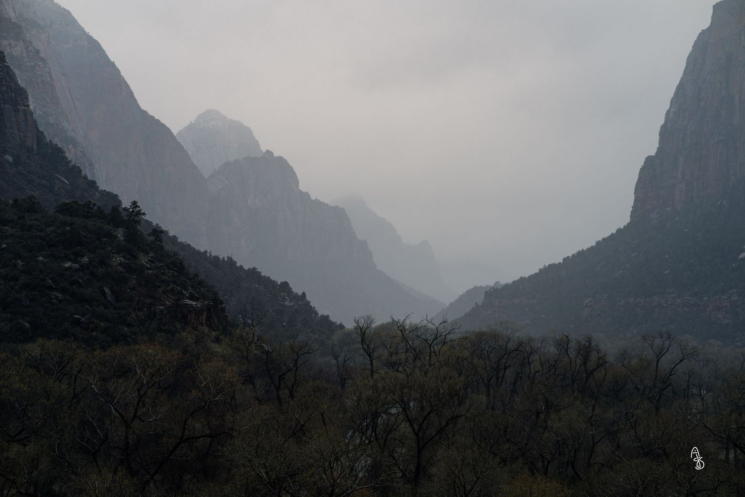 Moody landscape photo with Mountain with foggy peaks in distance.