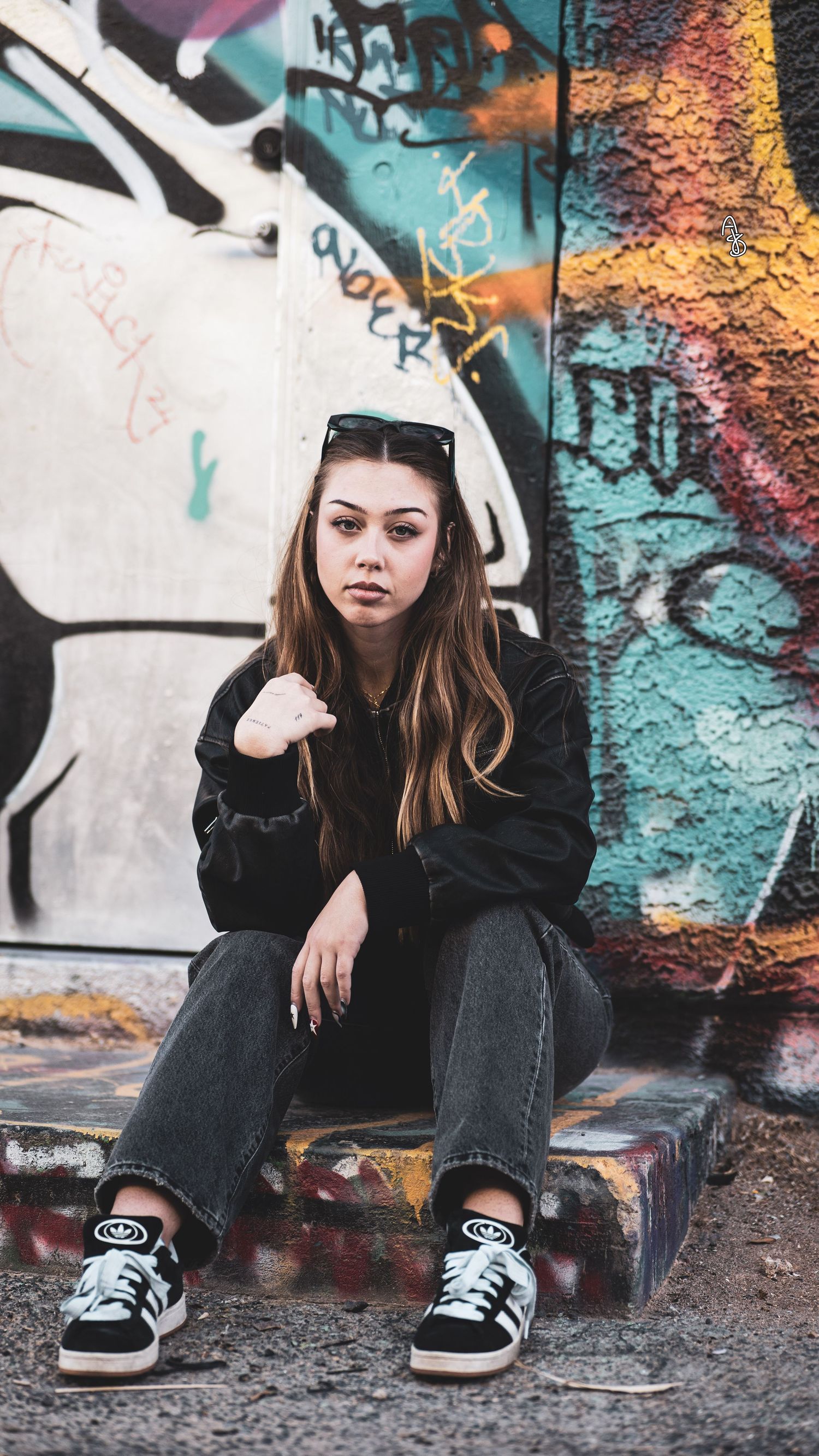 Woman with sunglasses sitting against graffiti wall. Las Vegas Art District photography. Grunge inspired photoshoot.