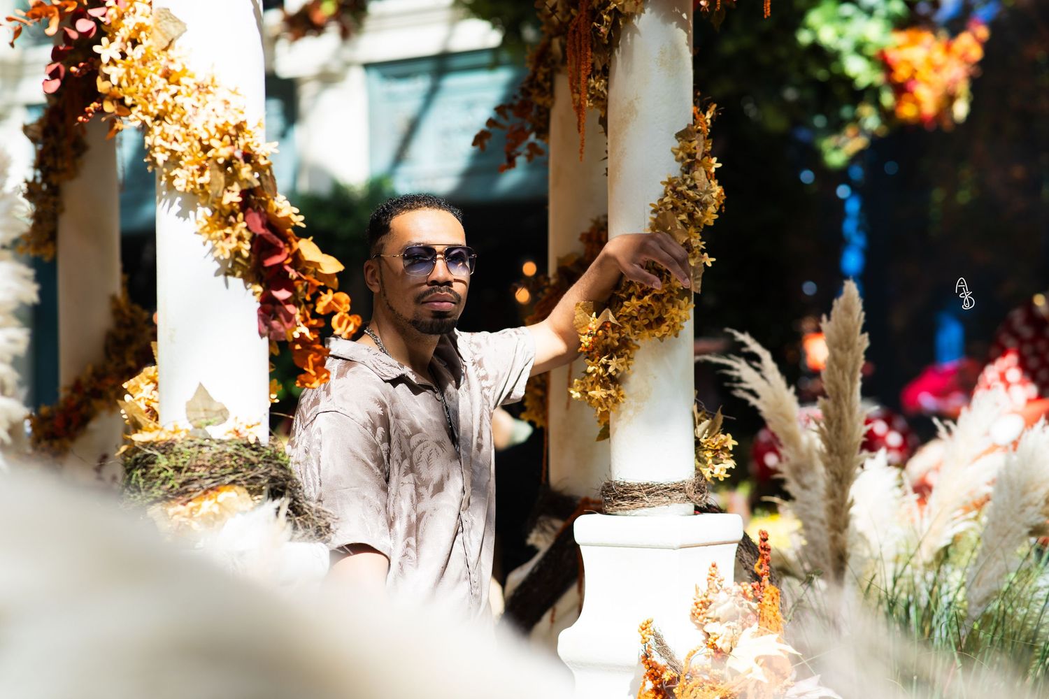 Man posing on fall decorated pillar in Las Vegas Bellagio Conservatory.