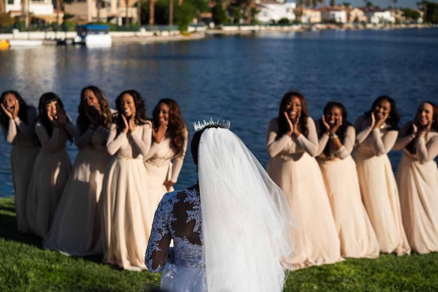 Bride facing bridesmaids cheerfully looking at bride in awe.