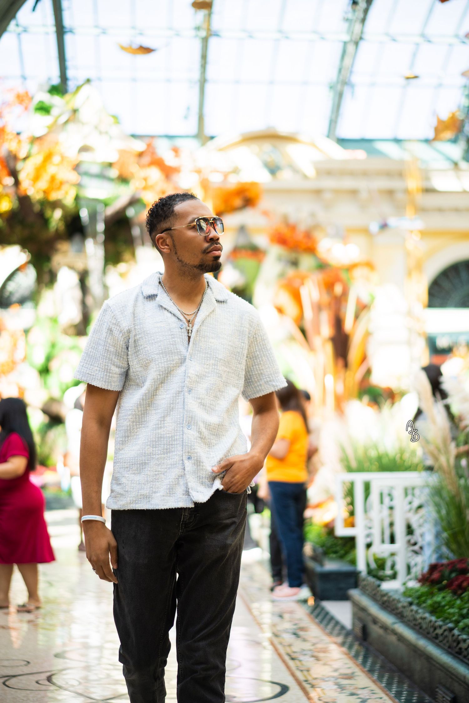 Man walking amidst crowd in Las Vegas Bellagio Conservatory.
