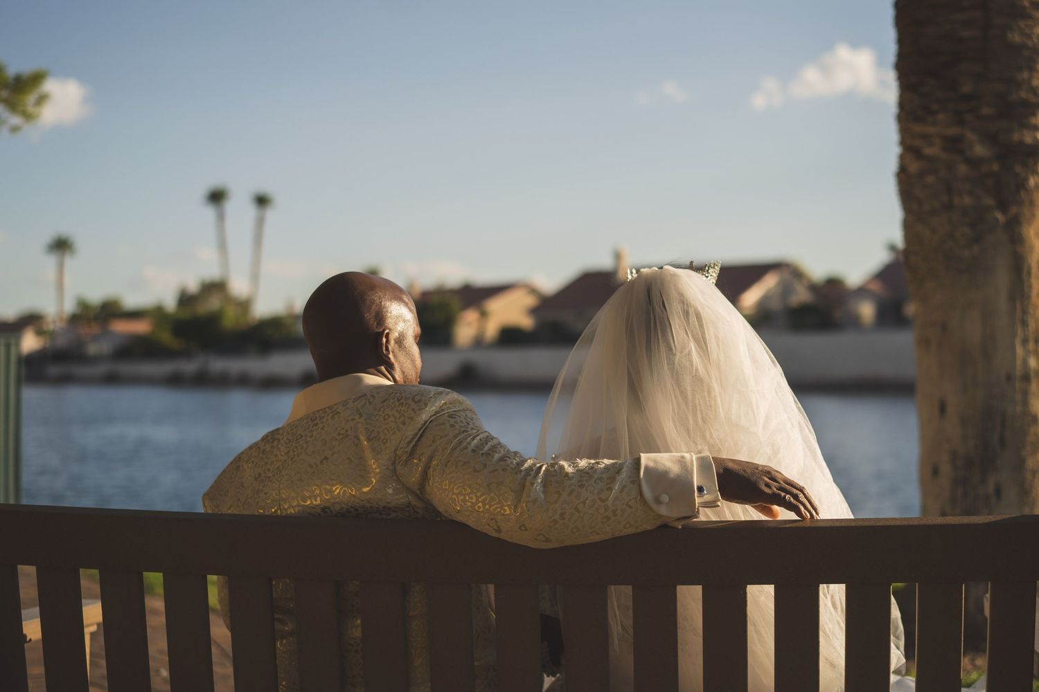 Las Vegas Bride and groom rest on bench looking out on lake view.