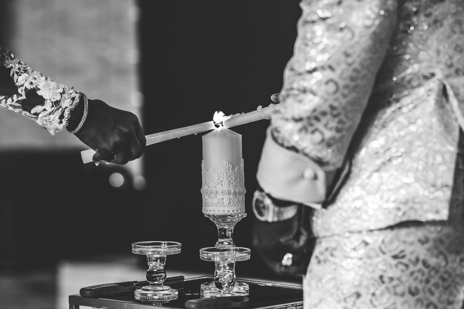 Bride and groom light marriage unity candle, black and white photography.