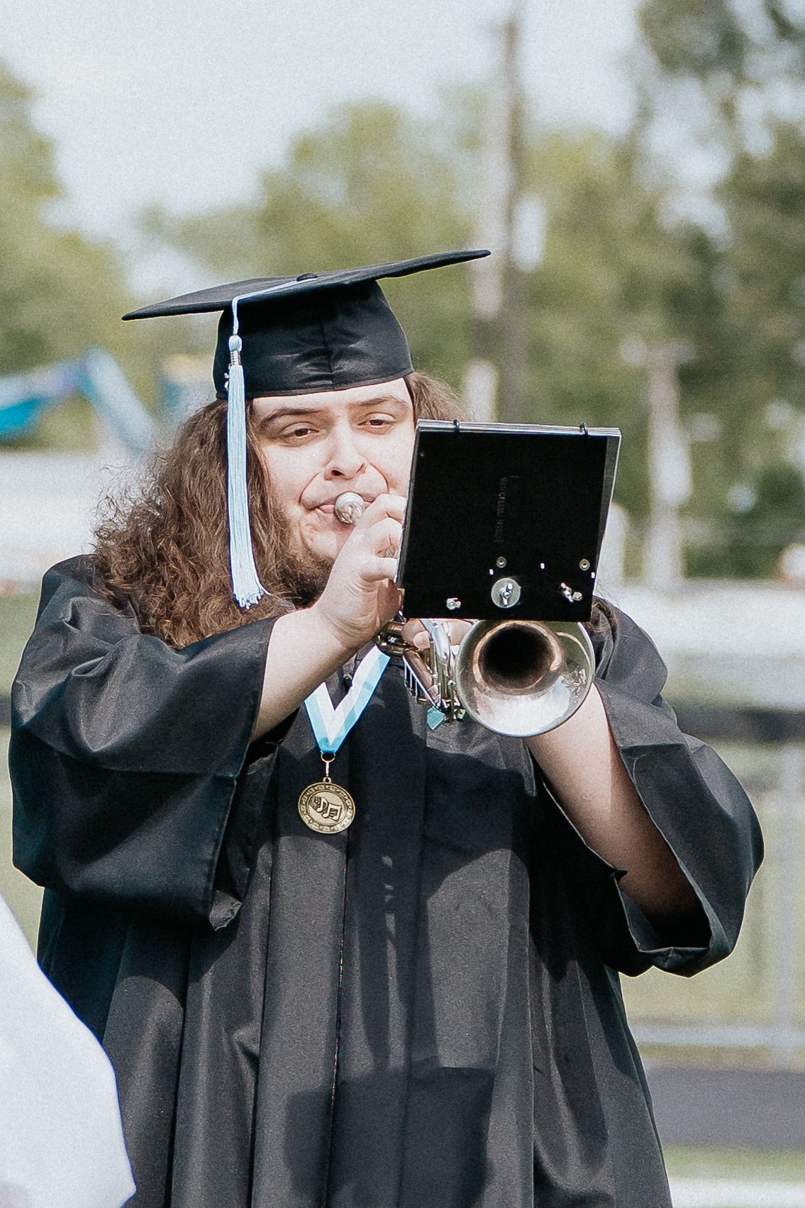Graduate moving their tassel from right to left during commencement ceremony while wearing traditional cap and gown.