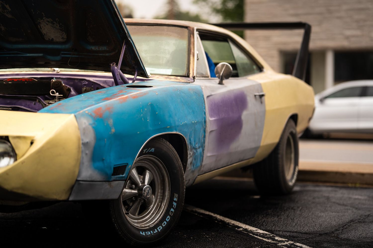 Artistic panoramic shot of vintage cars with multi-colored paint jobs.