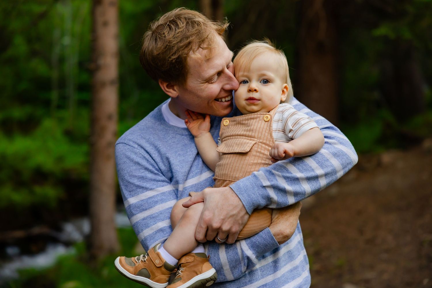 Sweet family moments captured with small baby in natural outdoor setting.
