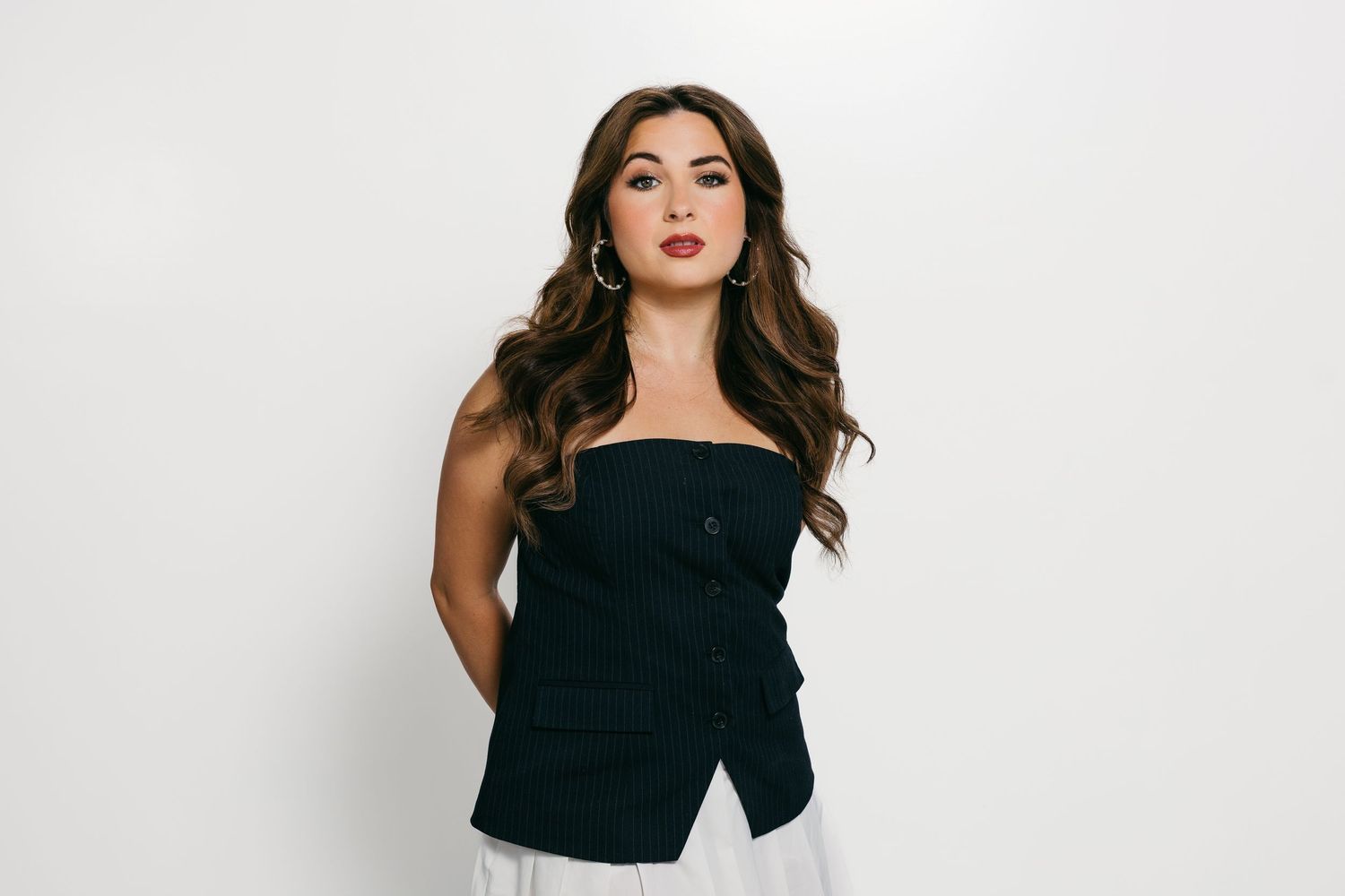 Studio portrait series of woman in black top against white background.