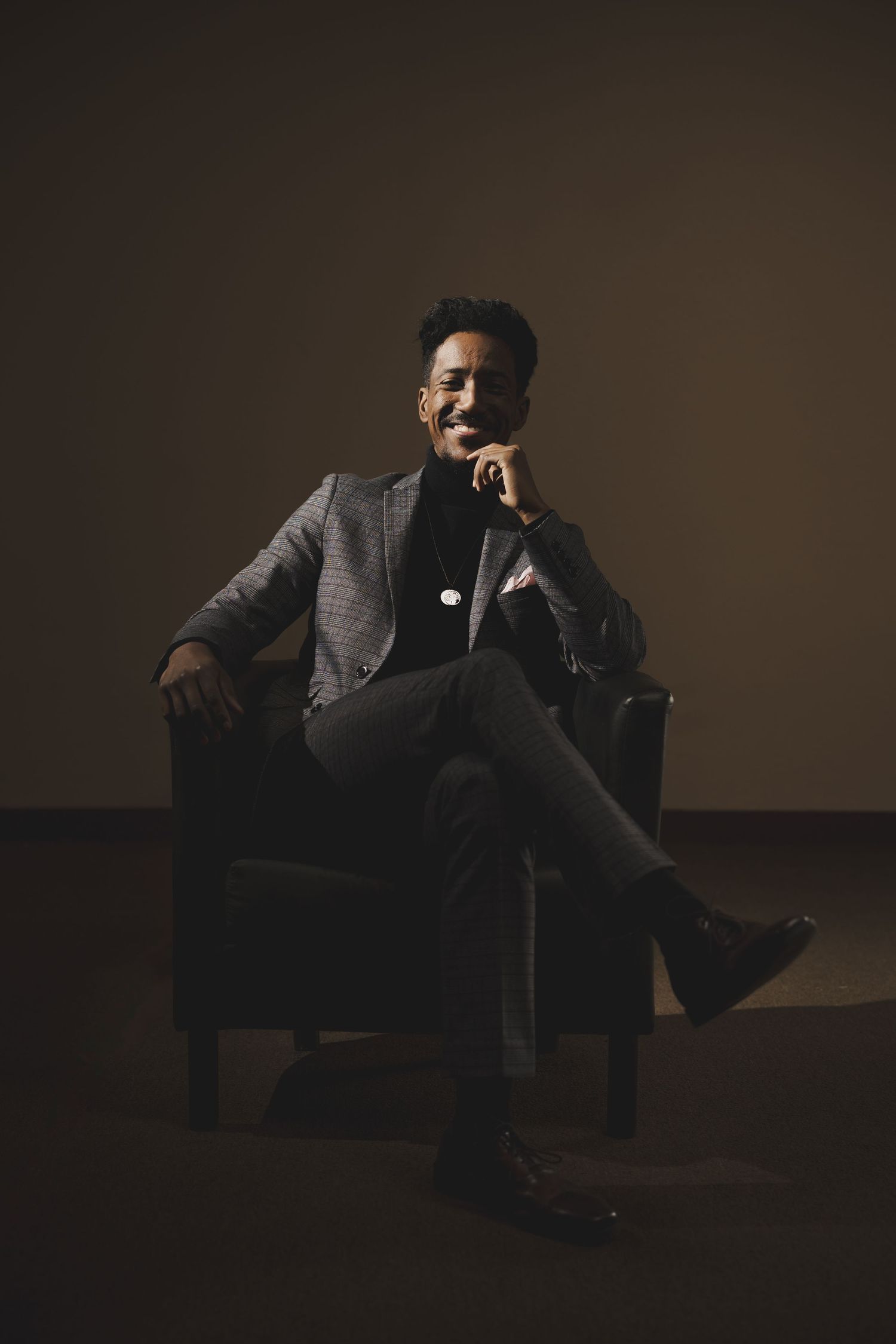 Moody portrait series featuring dramatic lighting and formal attire in dark setting.