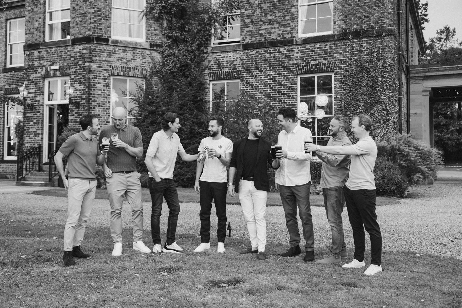 A series of black and white photographs showing groups of people standing together outdoors against brick buildings.