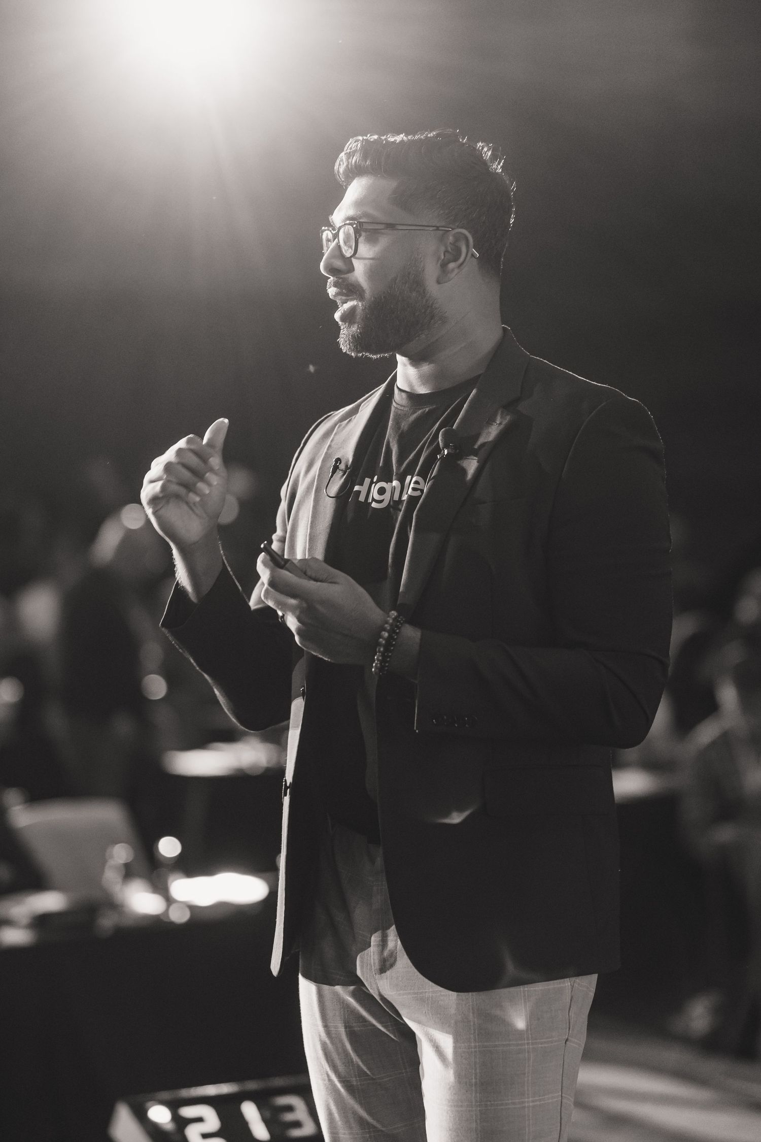 Dramatic black and white portrait of speaker presenting at professional event.