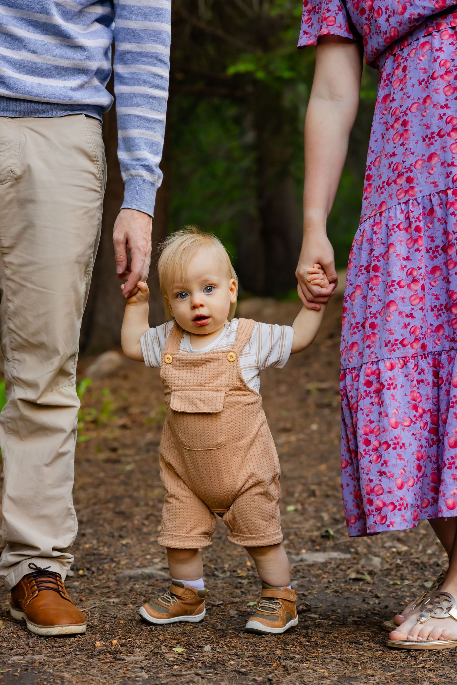 Close-up of walking feet and legs showing children's shoes and floral dress details.