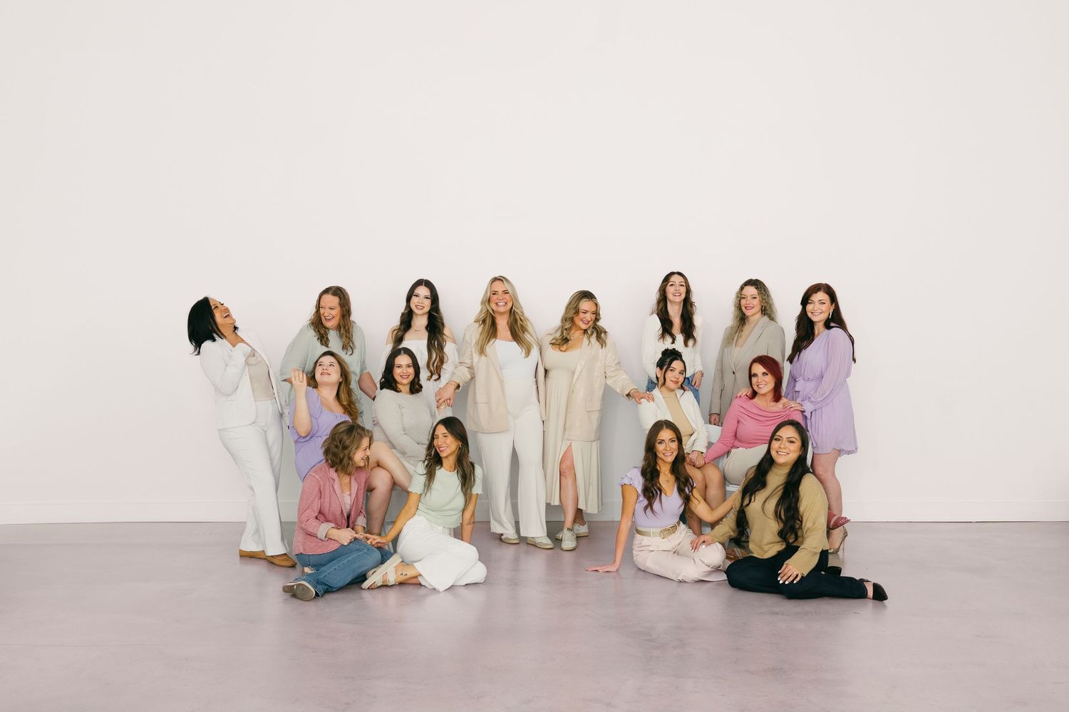 Professional group photo of women wearing coordinated casual outfits in a studio setting.