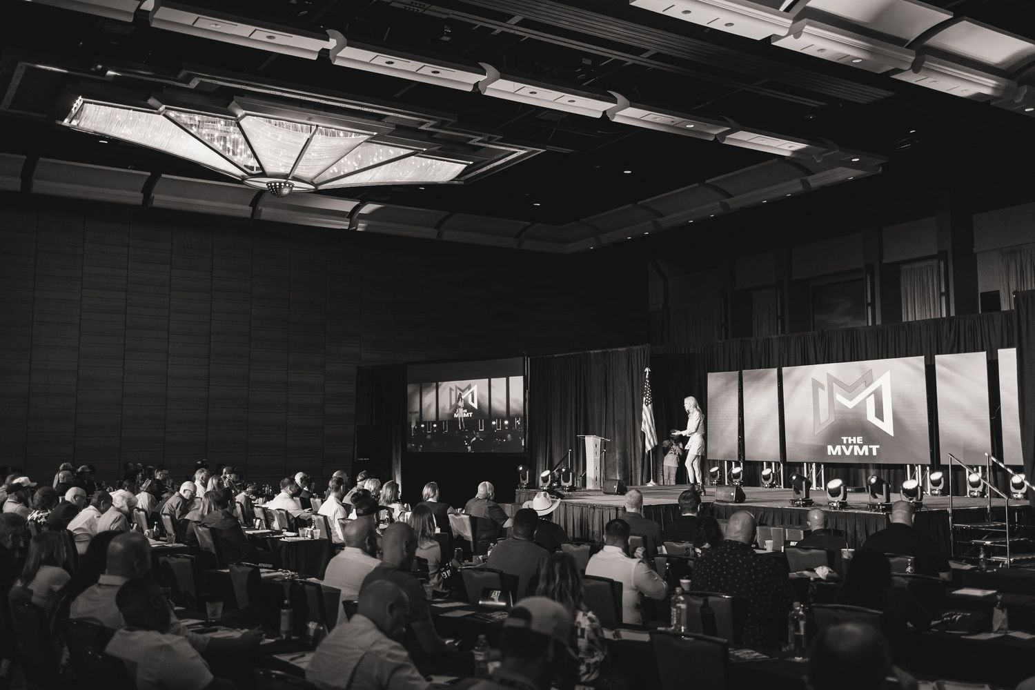 A panoramic view of an indoor conference or event space with rows of tables and seating.