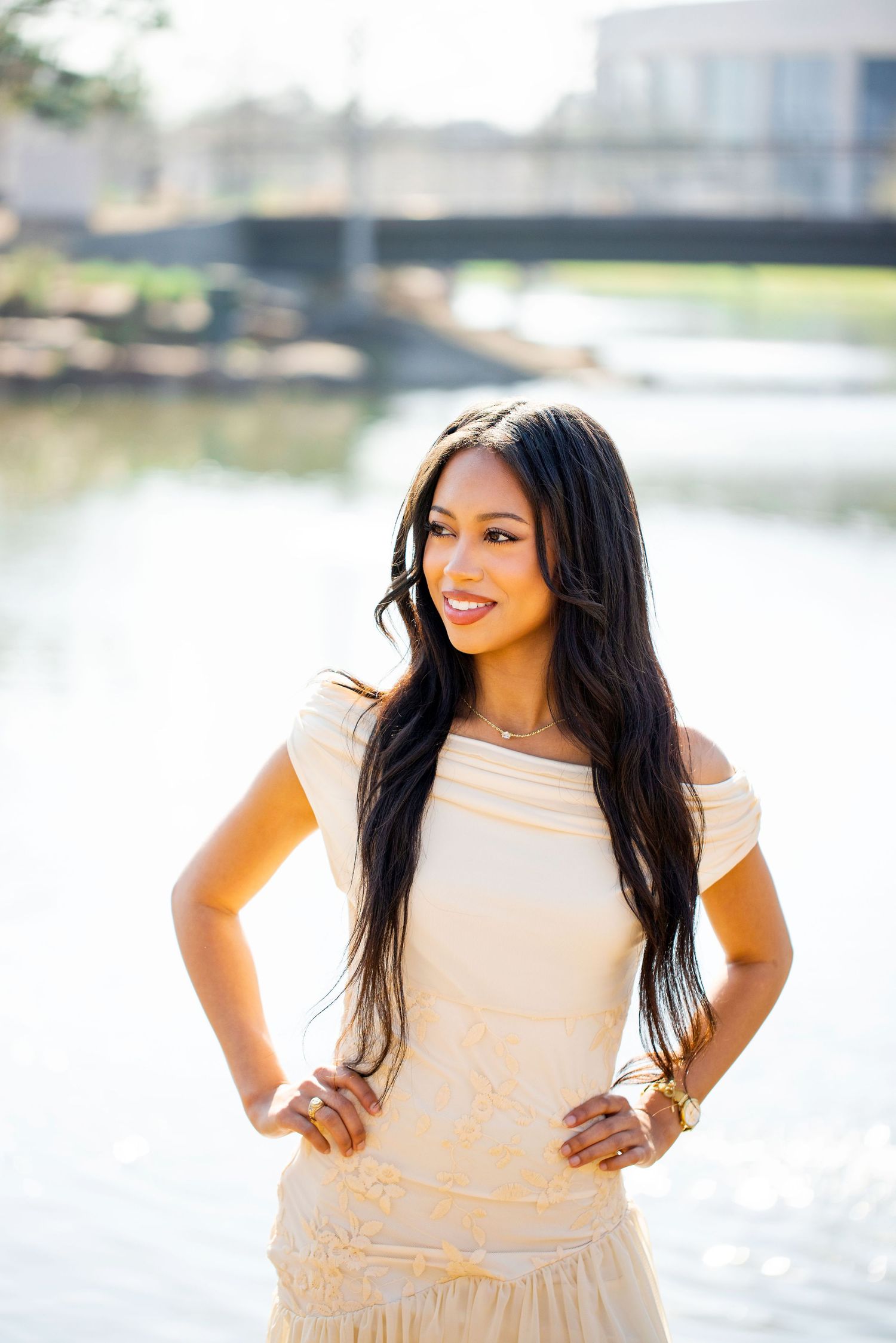 Elegant cream-colored outfit photographed by a serene waterfront setting.
