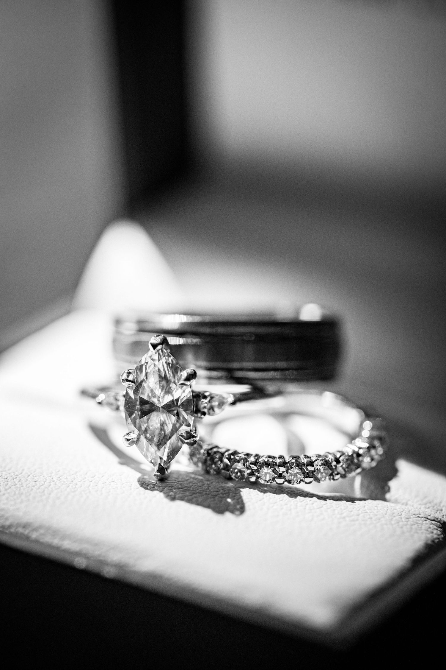 Diamond engagement ring and wedding band photographed in dramatic black and white.