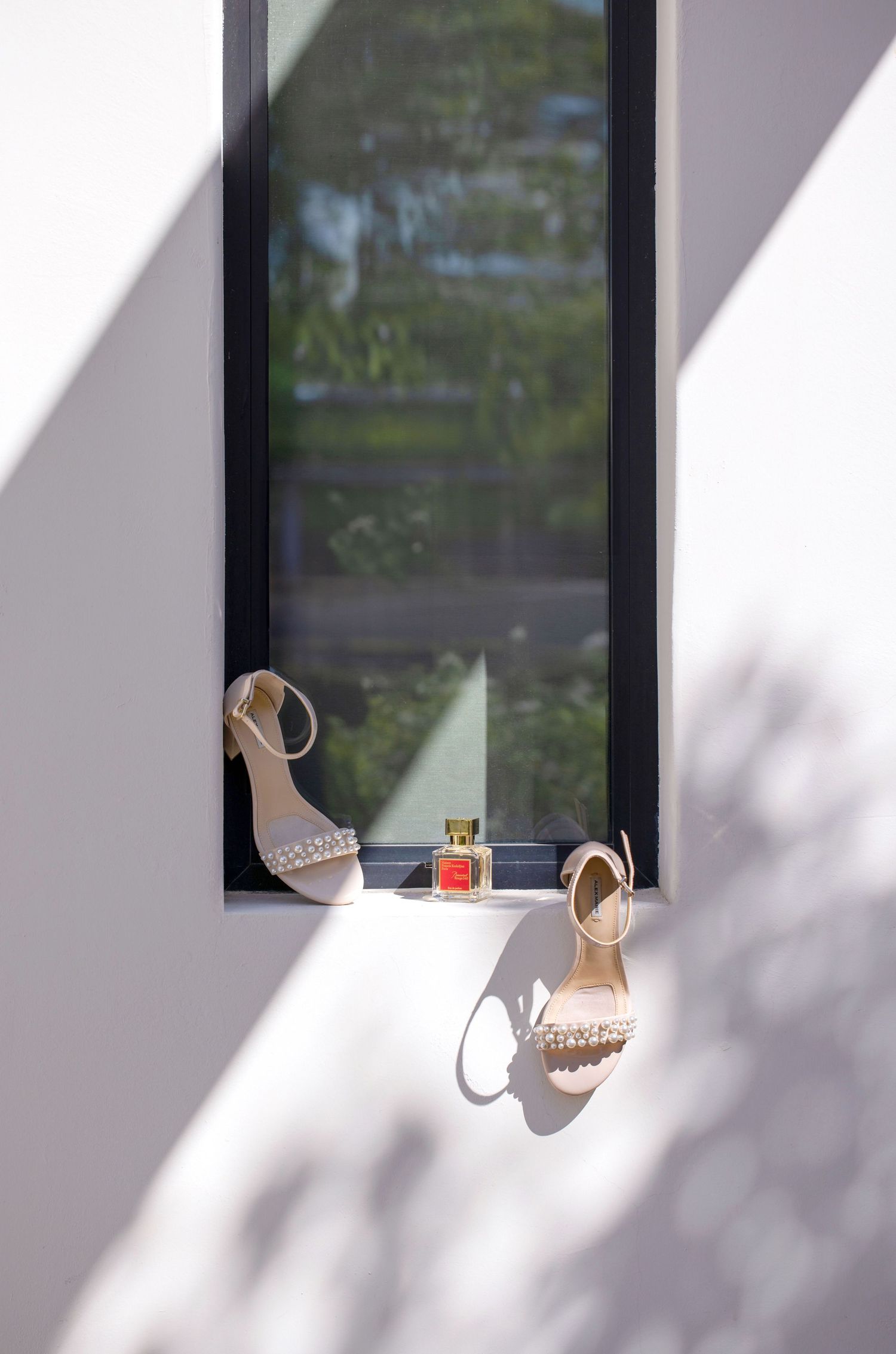 Wedding shoes displayed artistically in window light with dramatic shadows in Scottsdale, Arizona.