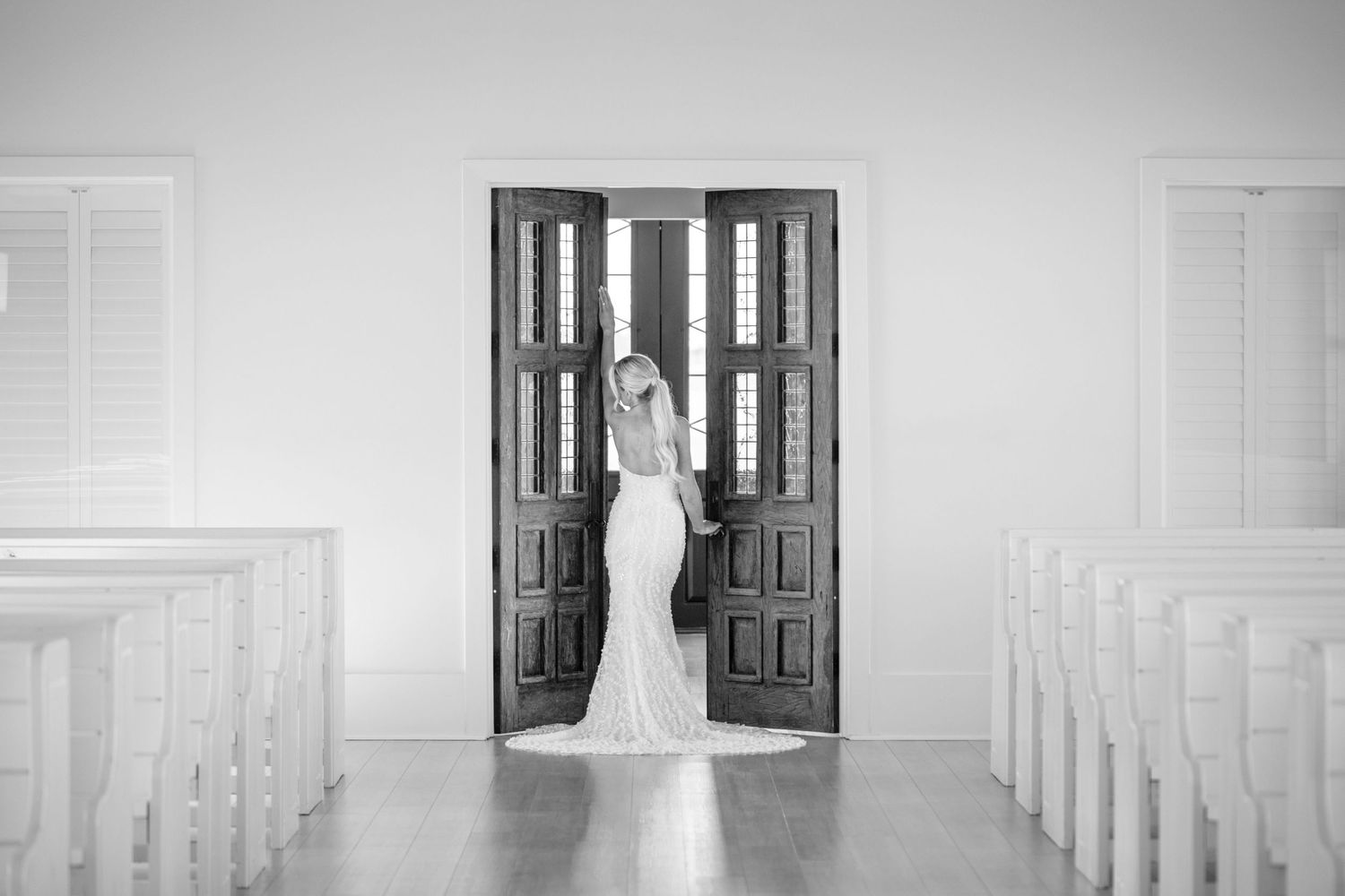 Bridal portraits showing a bride in a Unbridaled wedding dress walking through an elegant chapel hallway at Camp Hosea wedding venue.