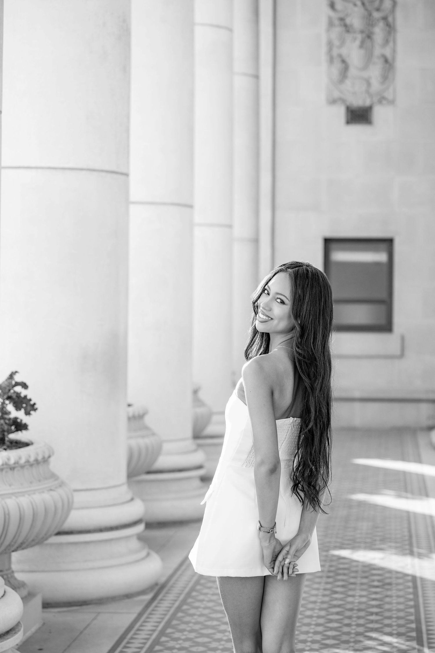 Black and white graduation portraits captured in elegant columned setting.