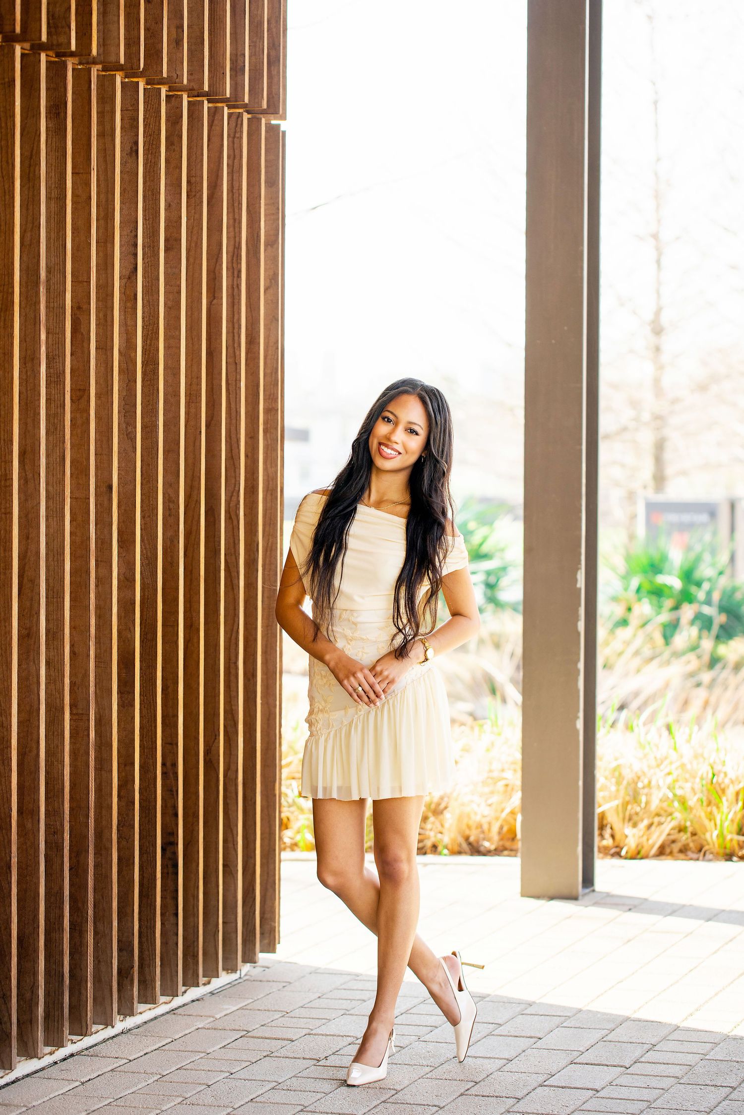 Playful poses between wooden columns create dynamic architectural framing.
