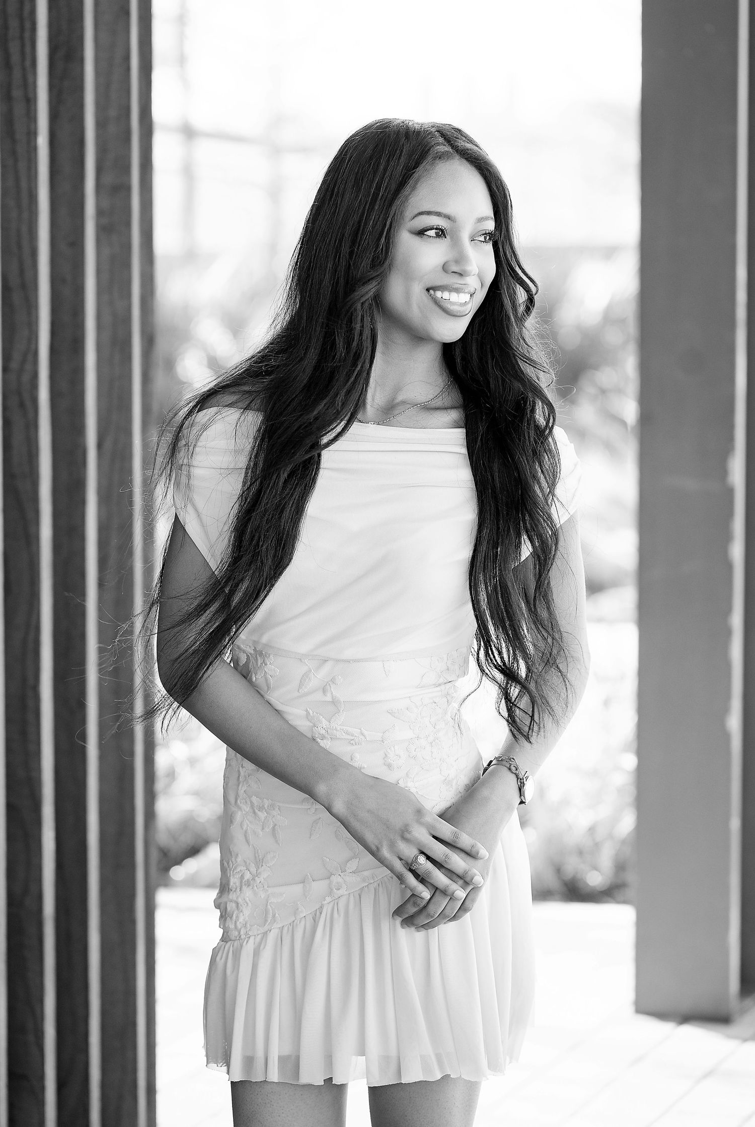 Black and white portrait series showing a person in a white dress posing against a column backdrop.