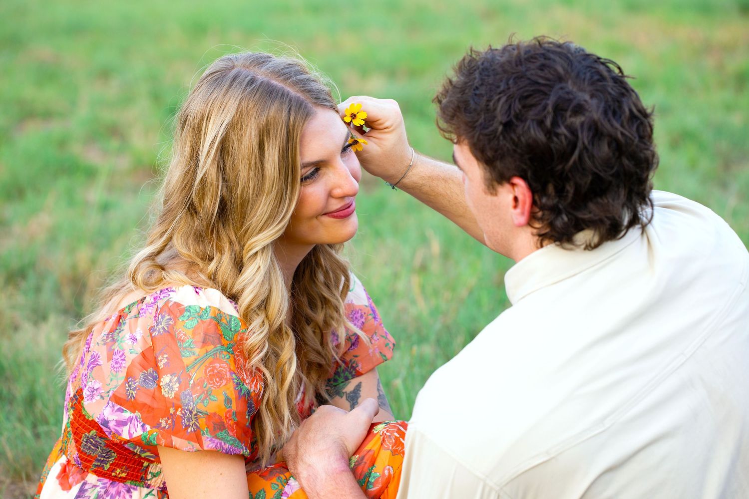 A couple in a romantic outdoor setting shares tender moments together in a series of candid photos on a grassy lawn.
