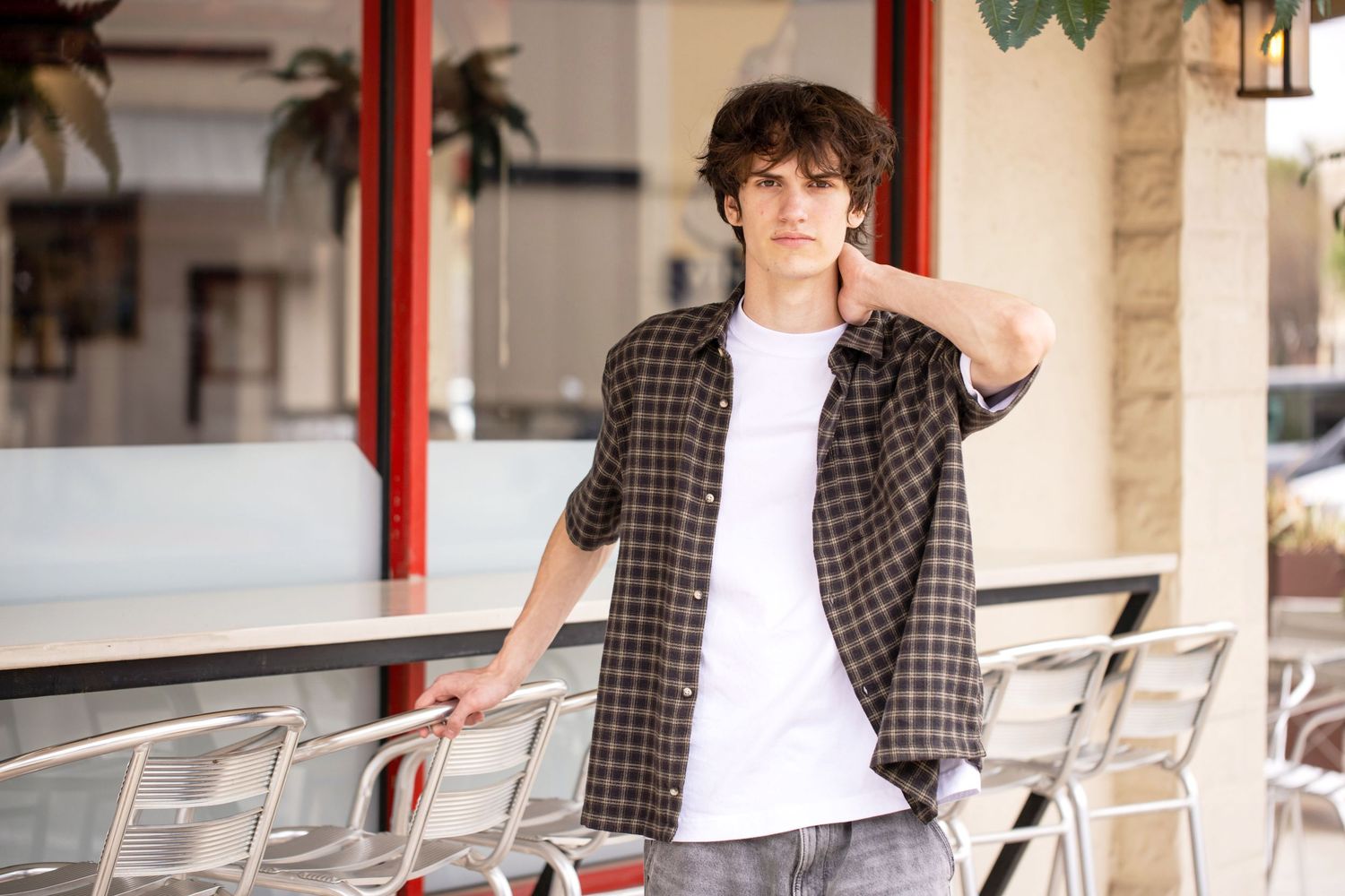 Champion High School senior, Casual outfit styled against architectural columns and railings in warm sunlight in downtown Boerne, Texas.